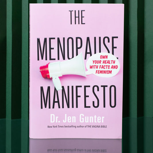 pink paperbook book The Menopause Manifesto by Dr. Jen Gunter on a green background