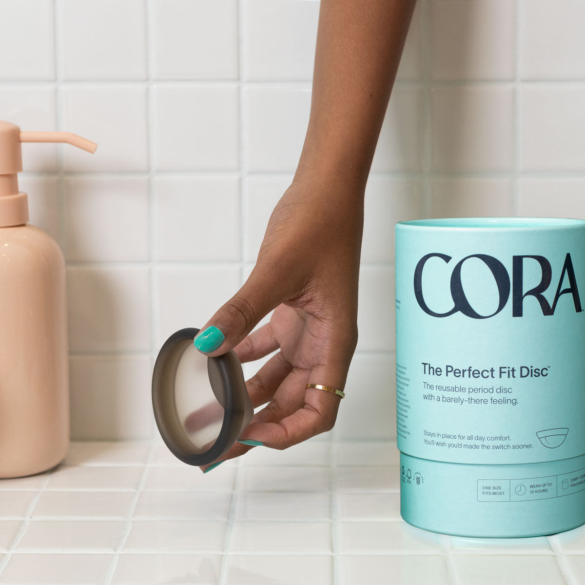 cora perfect fit disc in model hand on white tiles