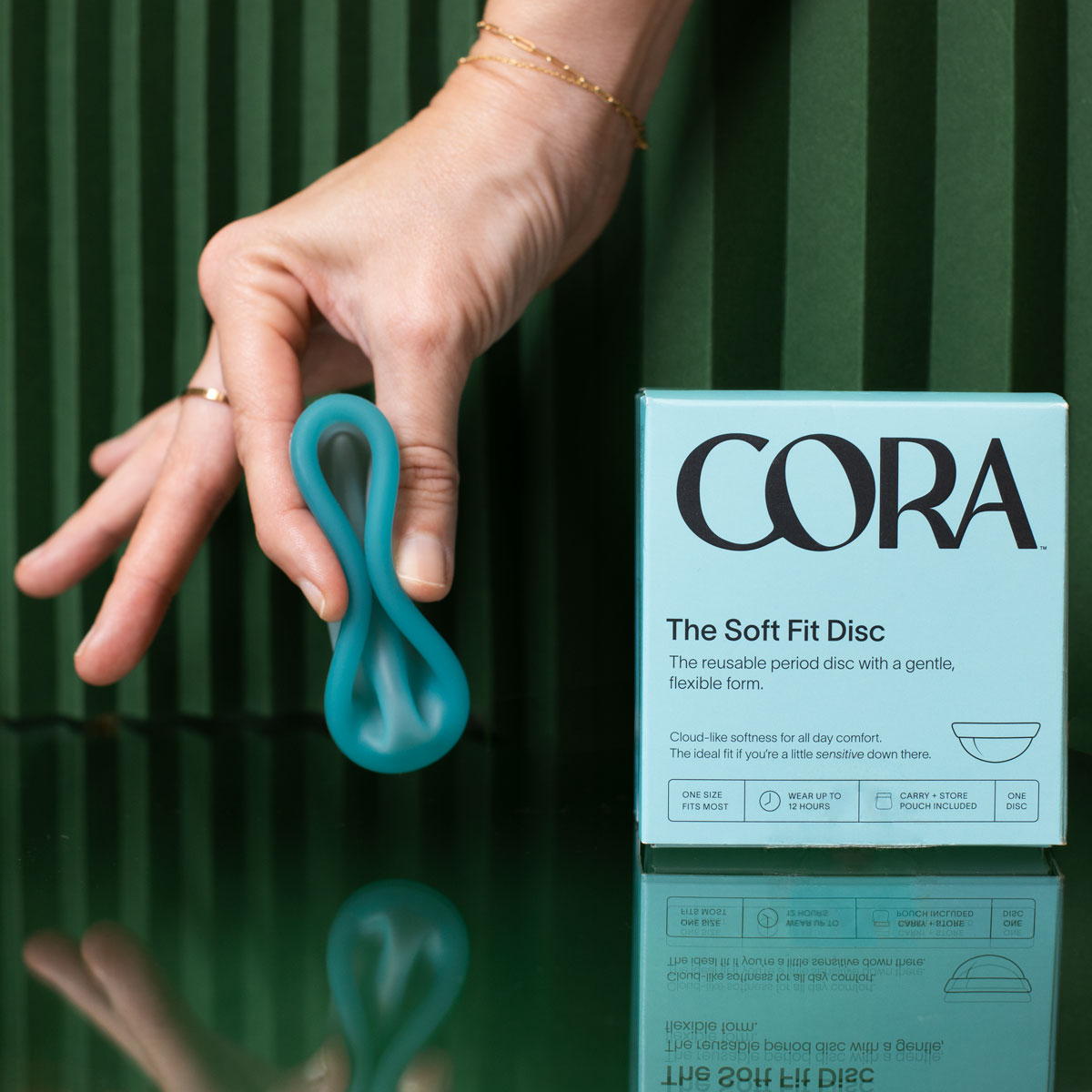 cora soft fit disc blue folded by white hand next to blue box package